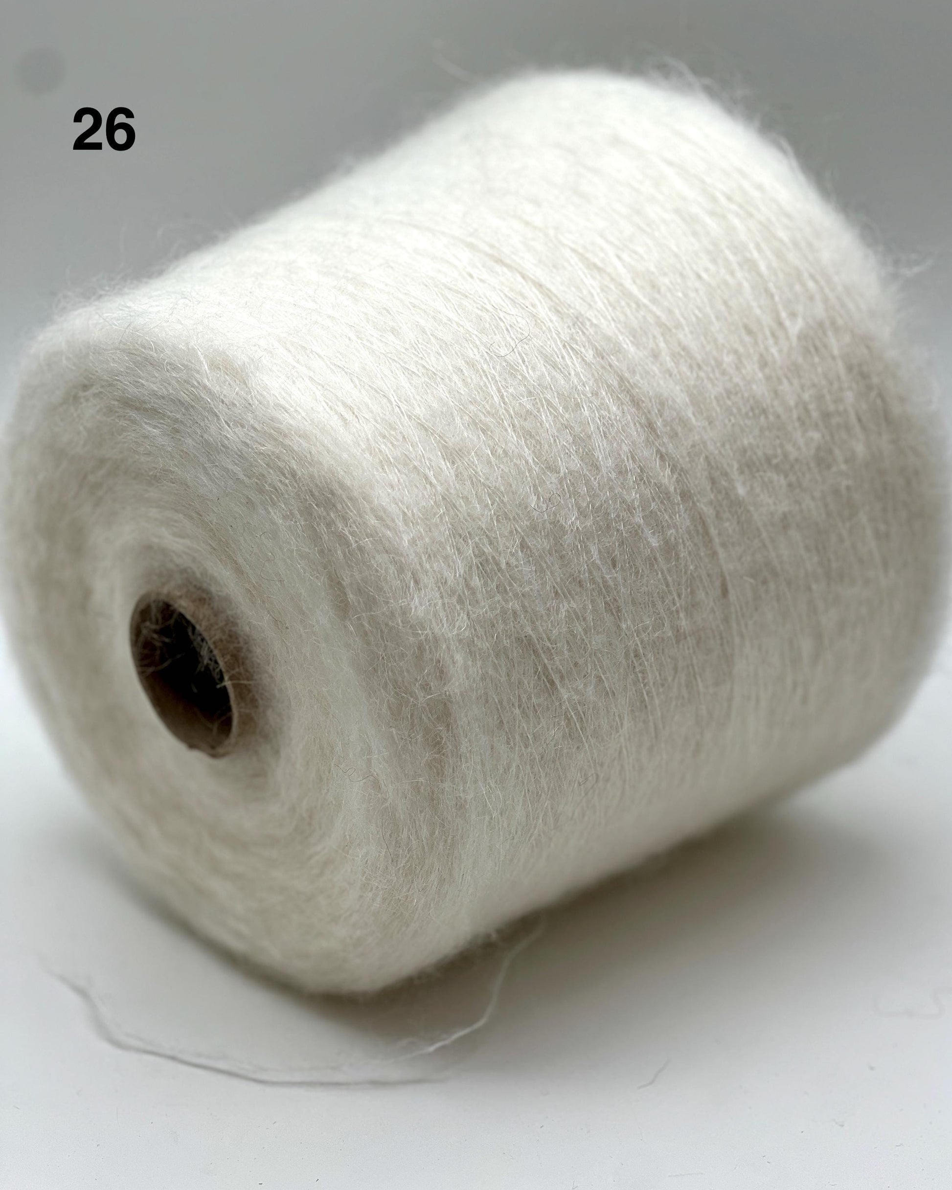 Spool of white yarn on a light gray background