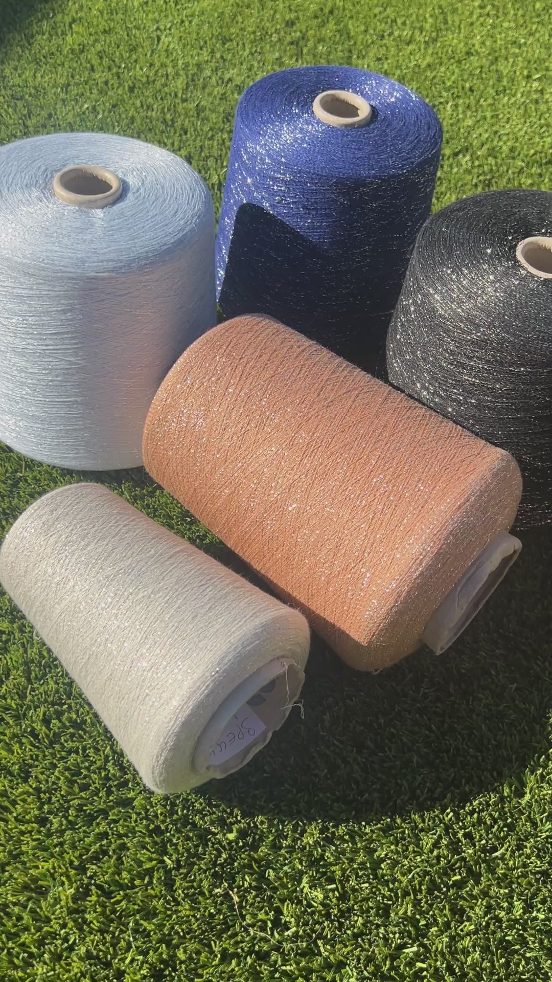 A luxurious cone of Pecci Filati SHIMMER yarn, a modern 50% Cotton, 25% Linen, 14% Polyester, and 12% Polyamide (Lurex) blend. The image showcases the refined metallic glow and delicate texture of this 3400m/100g Italian extrafine yarn, ideal for high-end blending. Authentic luxury fiber available at iDOKNiT.com.