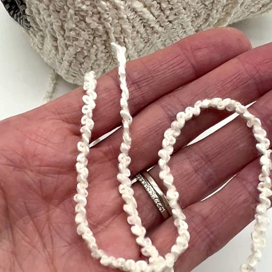 Italian cotton bouclé yarn on cone with looped textured surface