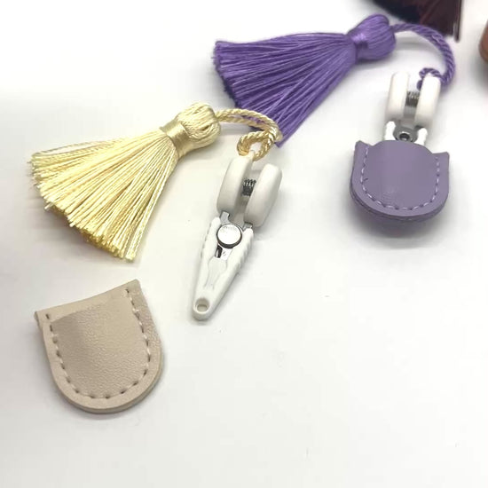 Professional iDOKNiT mini precision thread scissors for crafters. These 42mm spring-style snips feature a decorative tassel and protective cover, designed for sharp, precise trimming of yarn and embroidery floss. Compact and travel-ready accessory curated by iDOKNiT for knitting, crochet, and sewing project bags.