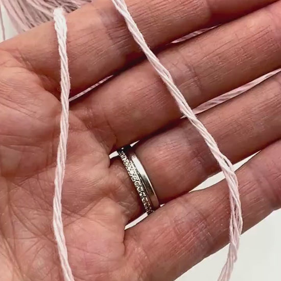 A curated collection of RiGo Supergeelong premium merino wool yarn in a palette of sophisticated neutrals and soft pinks. The image highlights the smooth, even texture and excellent stitch definition of this 100% Italian-made DK/Sport weight fiber. Authentic luxury yarn available at iDOKNiT.com.