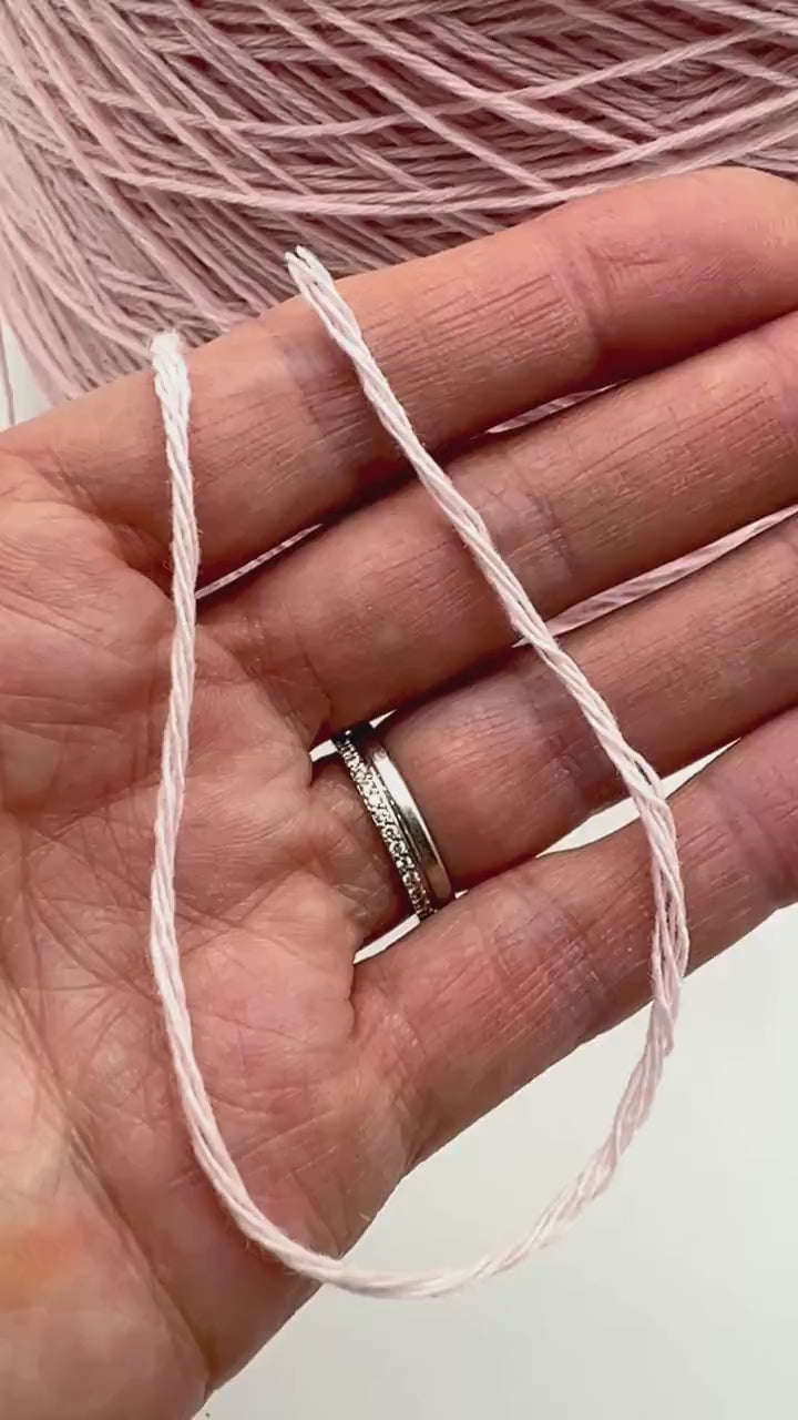 A curated collection of RiGo Supergeelong premium merino wool yarn in a palette of sophisticated neutrals and soft pinks. The image highlights the smooth, even texture and excellent stitch definition of this 100% Italian-made DK/Sport weight fiber. Authentic luxury yarn available at iDOKNiT.com.