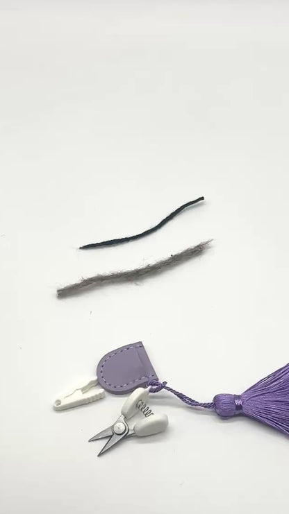 Professional iDOKNiT mini precision thread scissors for crafters. These 42mm spring-style snips feature a decorative tassel and protective cover, designed for sharp, precise trimming of yarn and embroidery floss. Compact and travel-ready accessory curated by iDOKNiT for knitting, crochet, and sewing project bags.