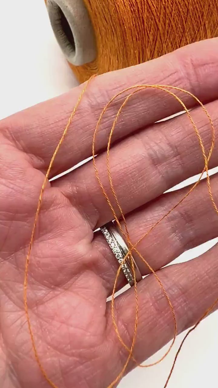 Emilcotoni Silk & Cotton lace yarn from Italy. Shown on professional cones in shades like Ochre, Navy Blue, and Brown. High-quality designer yarn for retail at iDOKNiT.com.